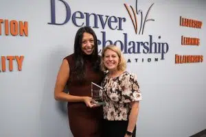 Kayla Garcia posing with DSF CEO Lorii Rabinowitz in front of DSF logo, holding her award
