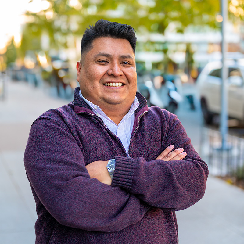 Carlos Cantor posing in front of a city sidewalk