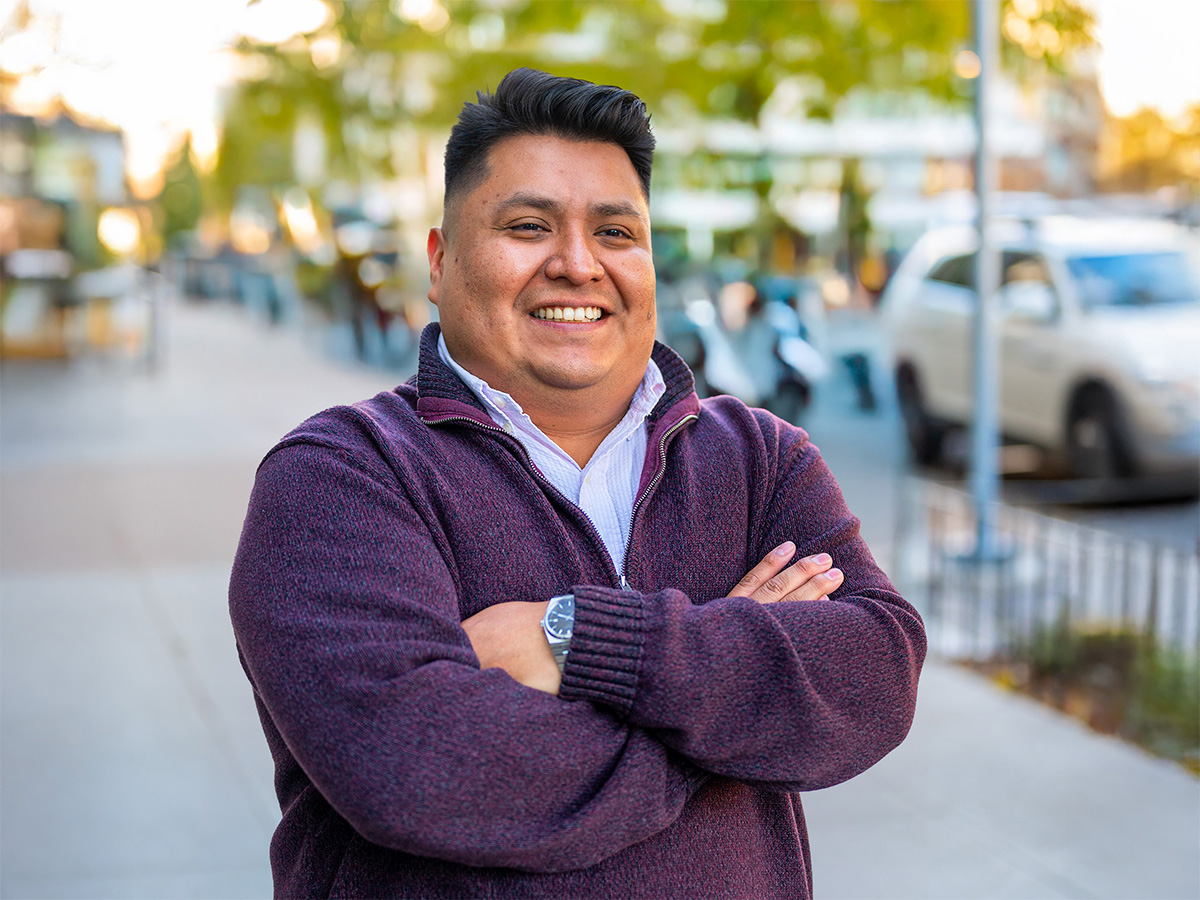 Carlos Cantor poses outside his office in front of colorful trees