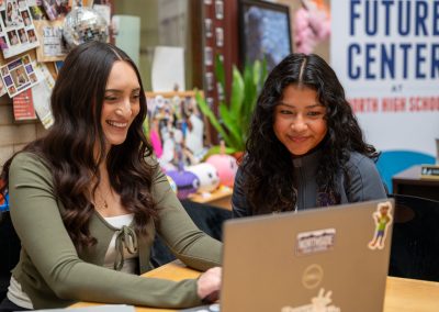 DSF College Advisor works on a laptop alongside a DPS student at the DSF Future Center at North High School