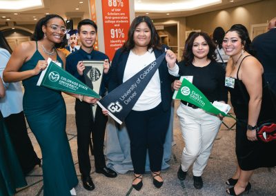 DSF College Advisors pose with students holding college flags at the DSF Gala