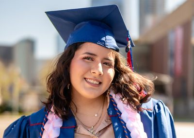 DSF Scholar Jessica, graduating from MSU Denver, smiles in front of the Denver skyline