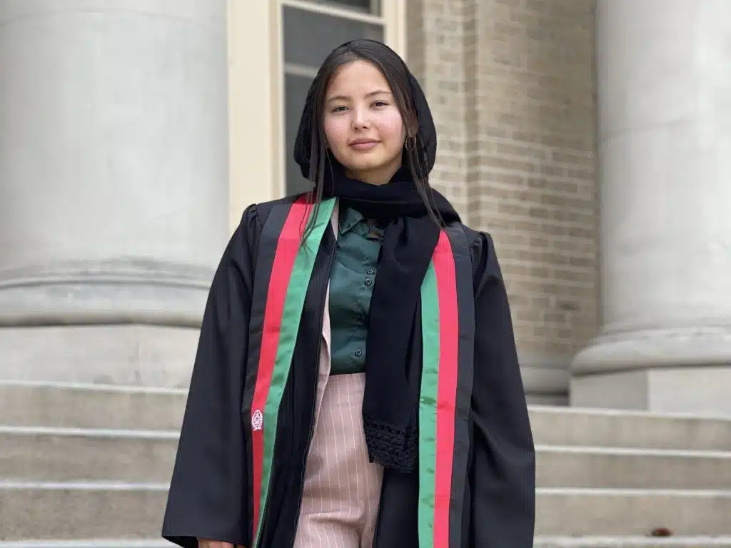 Sunbul Zeerak posing outside in graduation robe